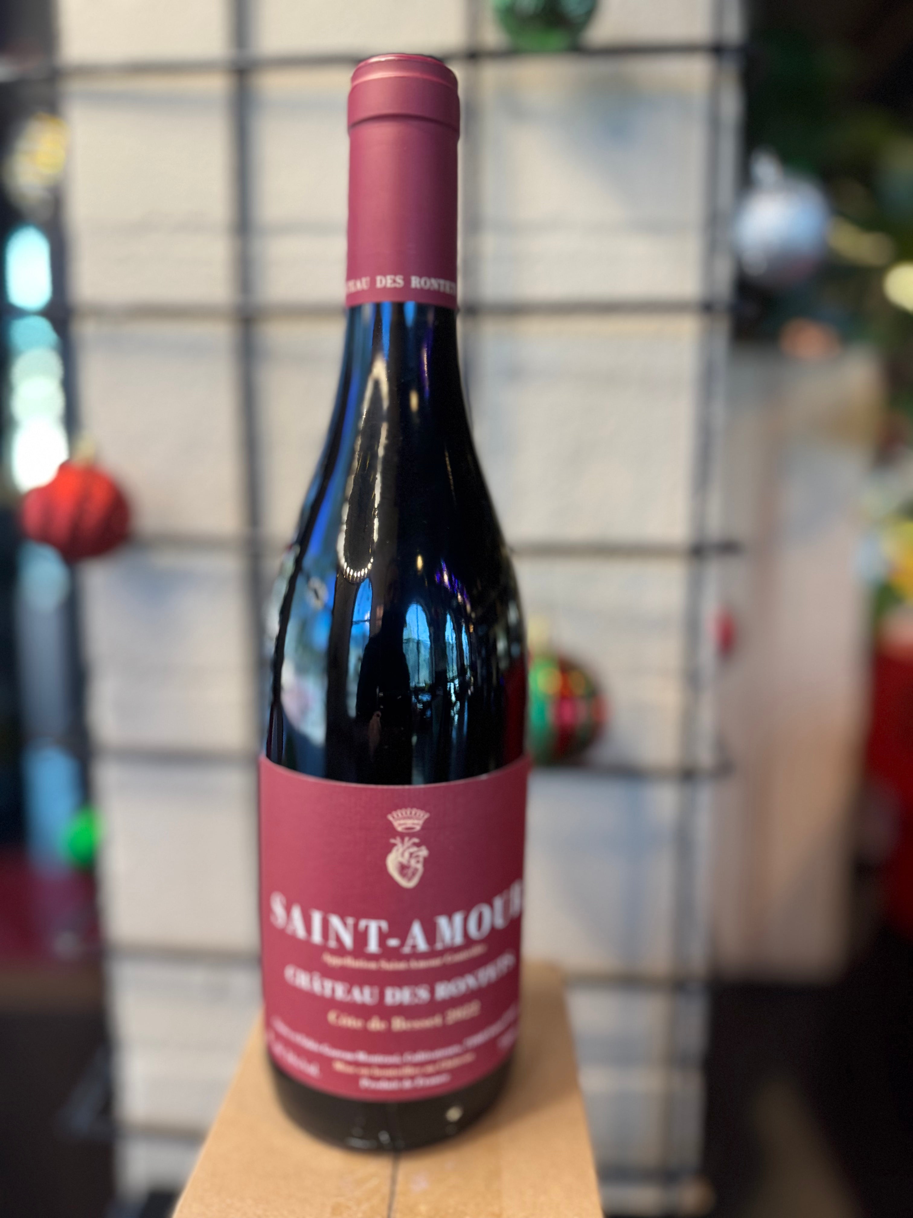 Wine bottle with 'Saint-Amour' label on a wooden surface with a blurred background