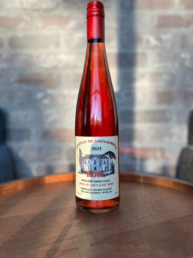 Bottle of 2024 rose wine on a wooden surface with a blurred background