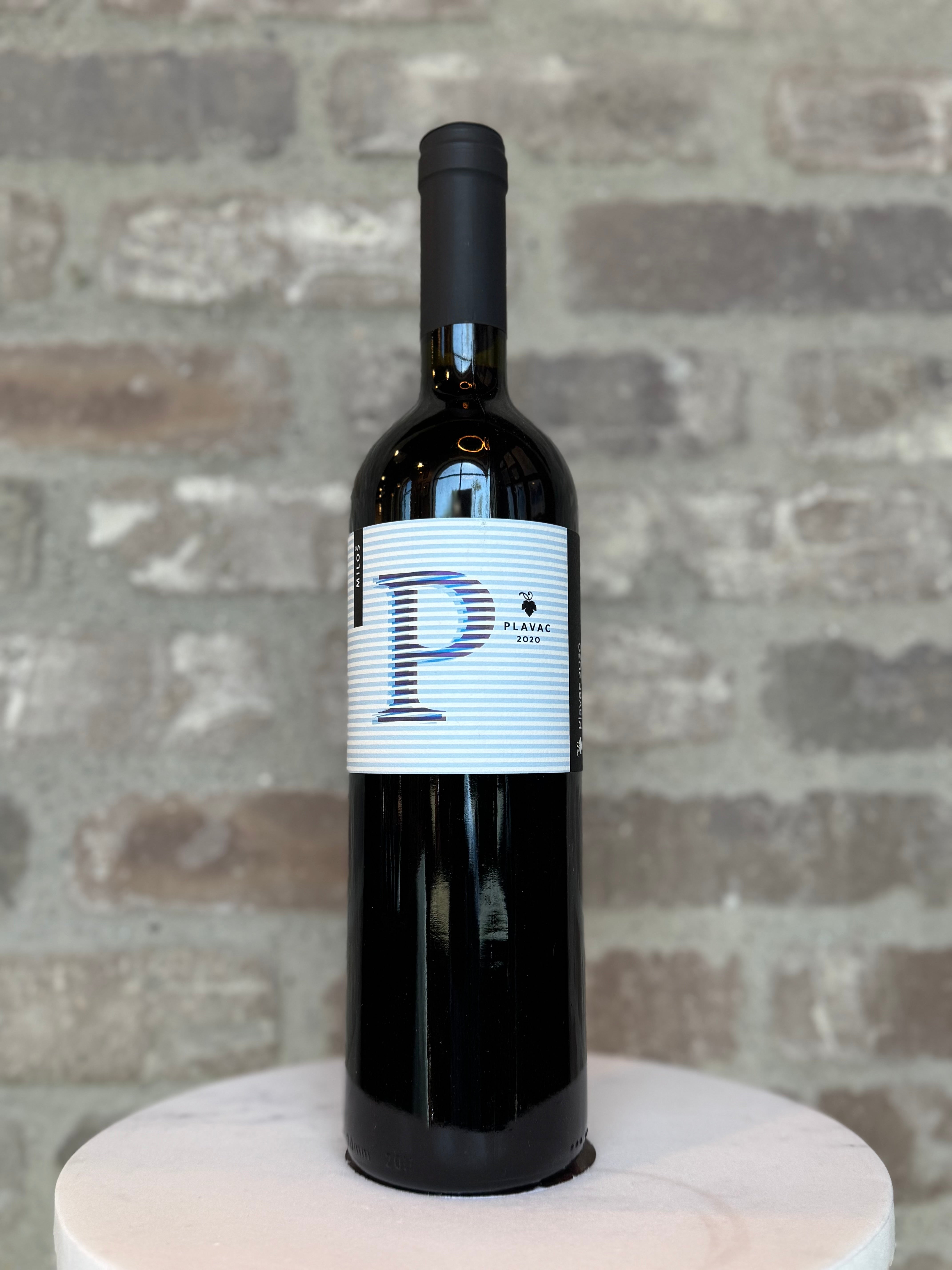 Wine bottle with a label featuring a large 'P' on a gray brick background