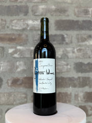 Wine bottle with a label on a marble surface against a brick wall background