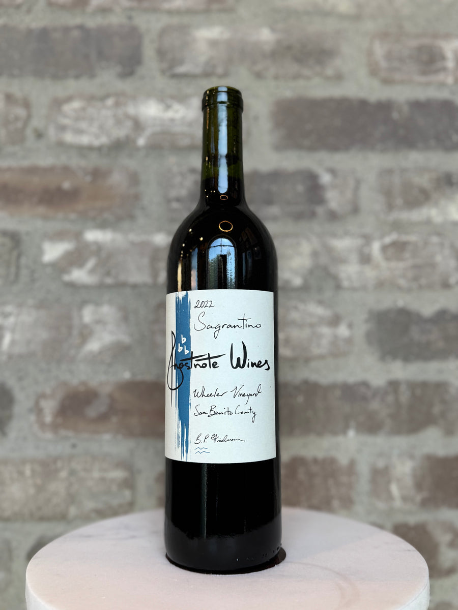 Wine bottle with a label on a marble surface against a brick wall background