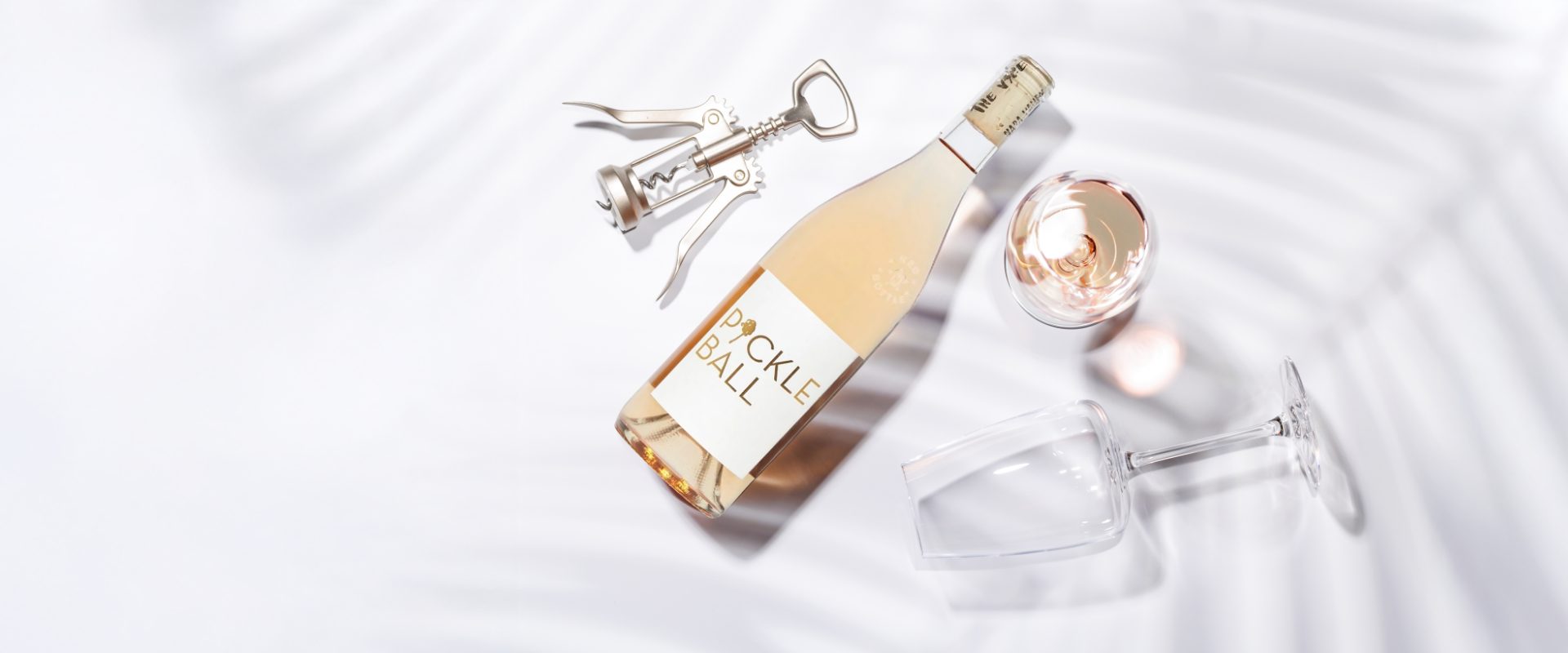 Bottle ofuckle & Vale champagne with a glass and corkscrew on a white background