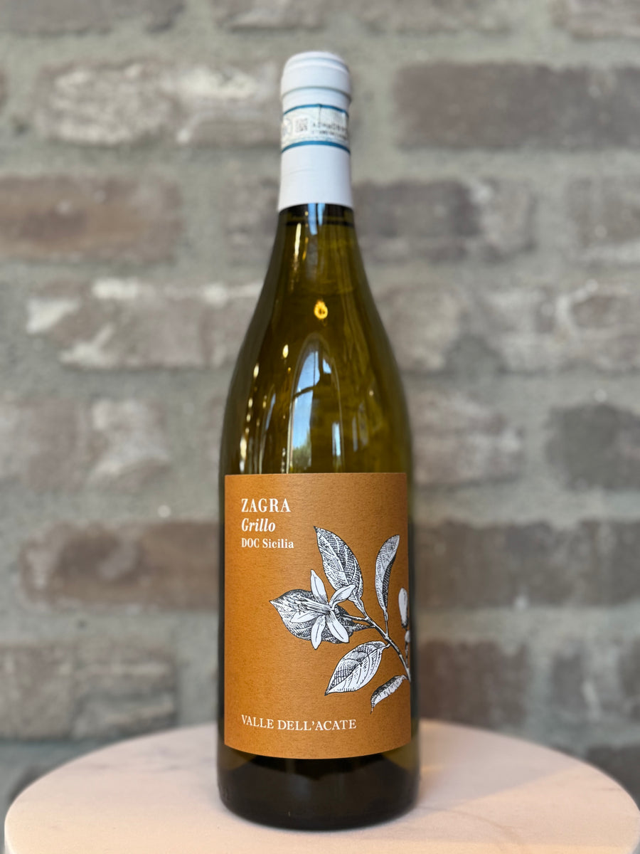 Wine bottle with a label on a wooden surface and stone wall background