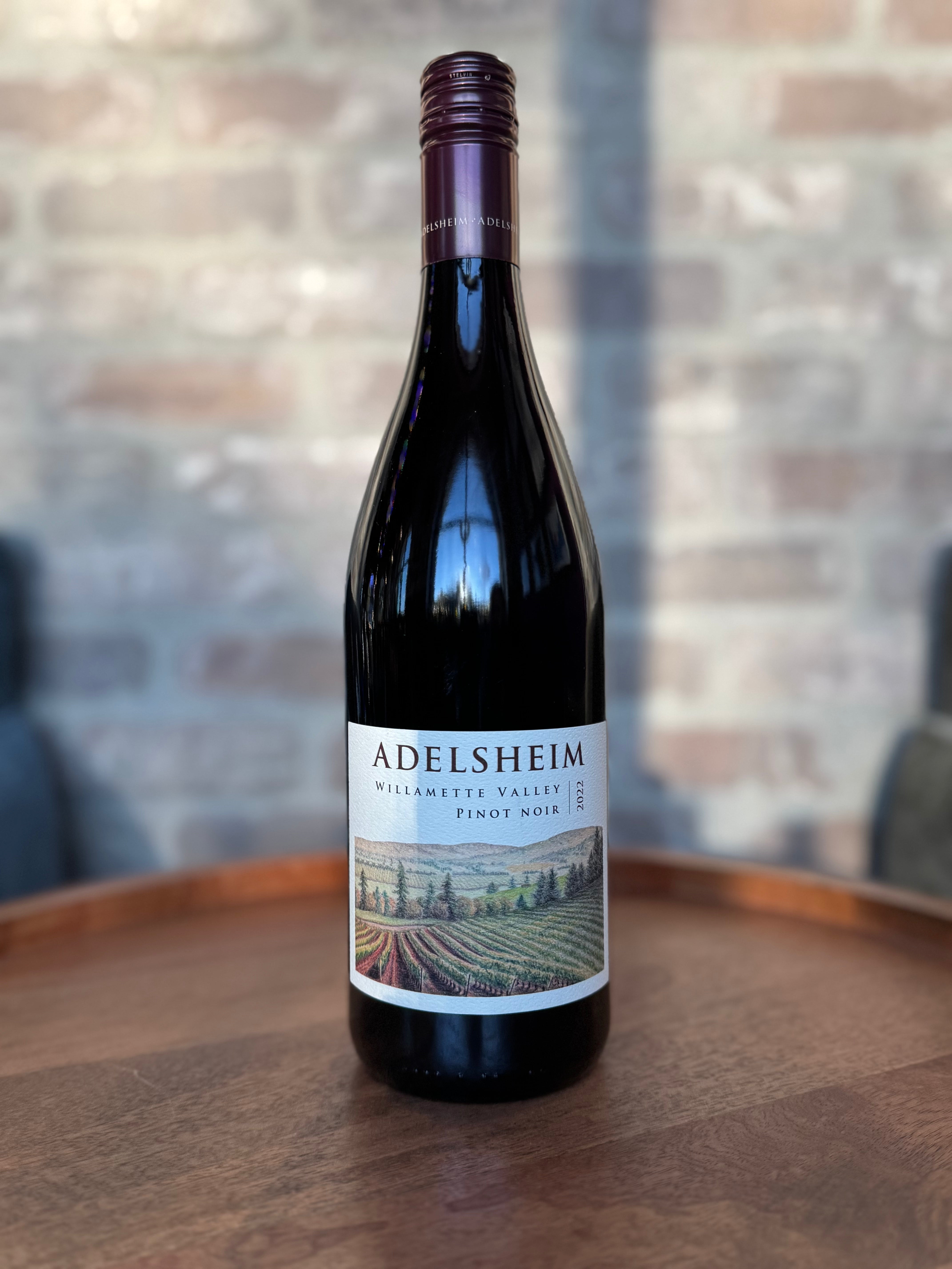 Adelsheim wine bottle on a wooden surface with a blurred background