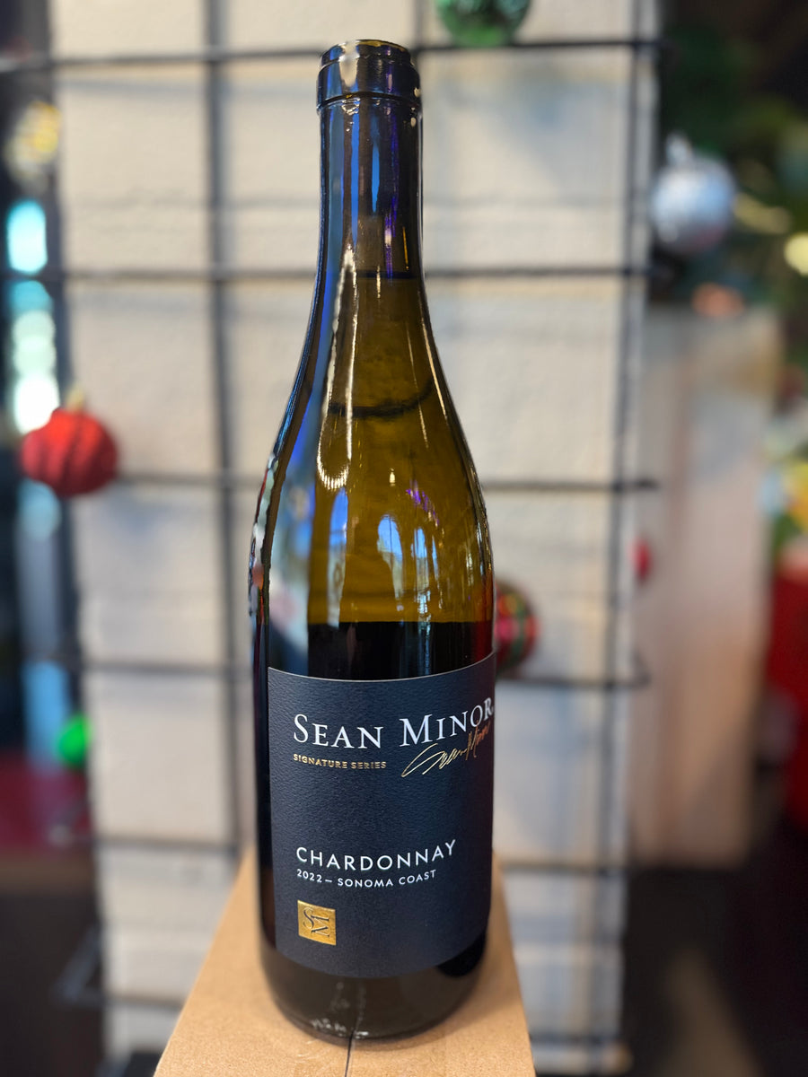 Wine bottle labeled 'Sean Minor Chardonnay' on a wooden surface with a blurred background