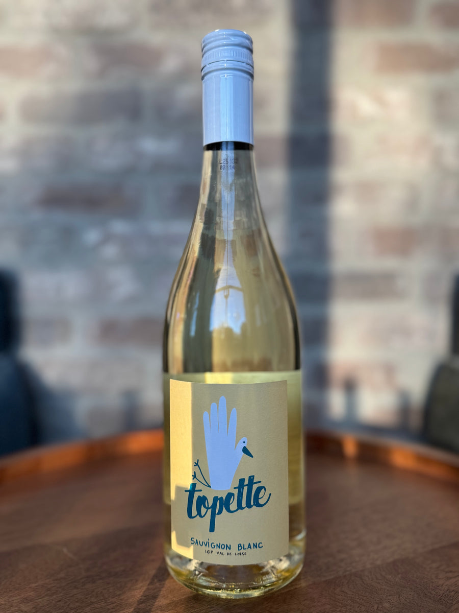 Bottle of topette Sauvignon Blanc wine on a wooden surface with a blurred background