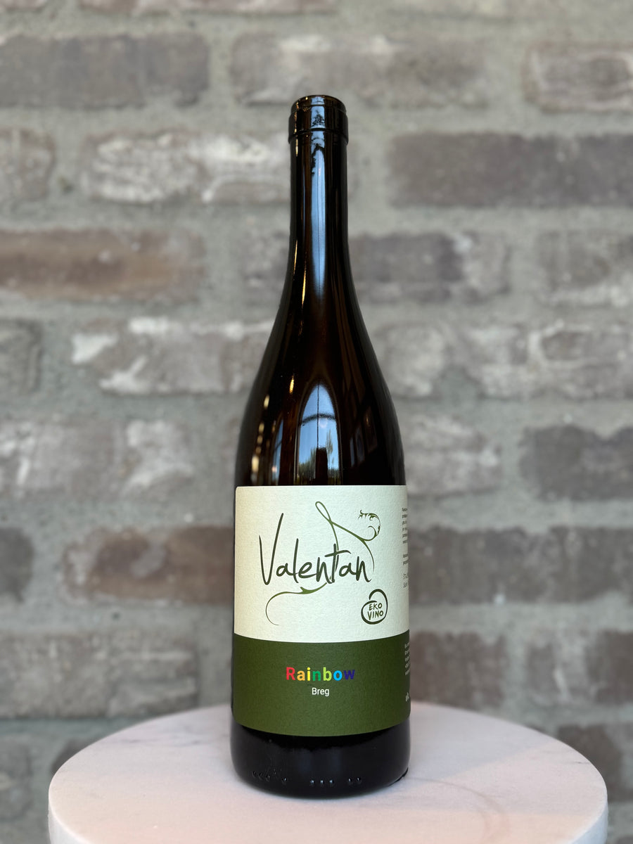 Wine bottle with a label on a round white surface against a brick wall background