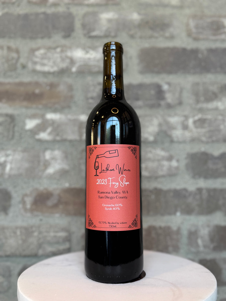 Wine bottle with a pink label on a gray stone background