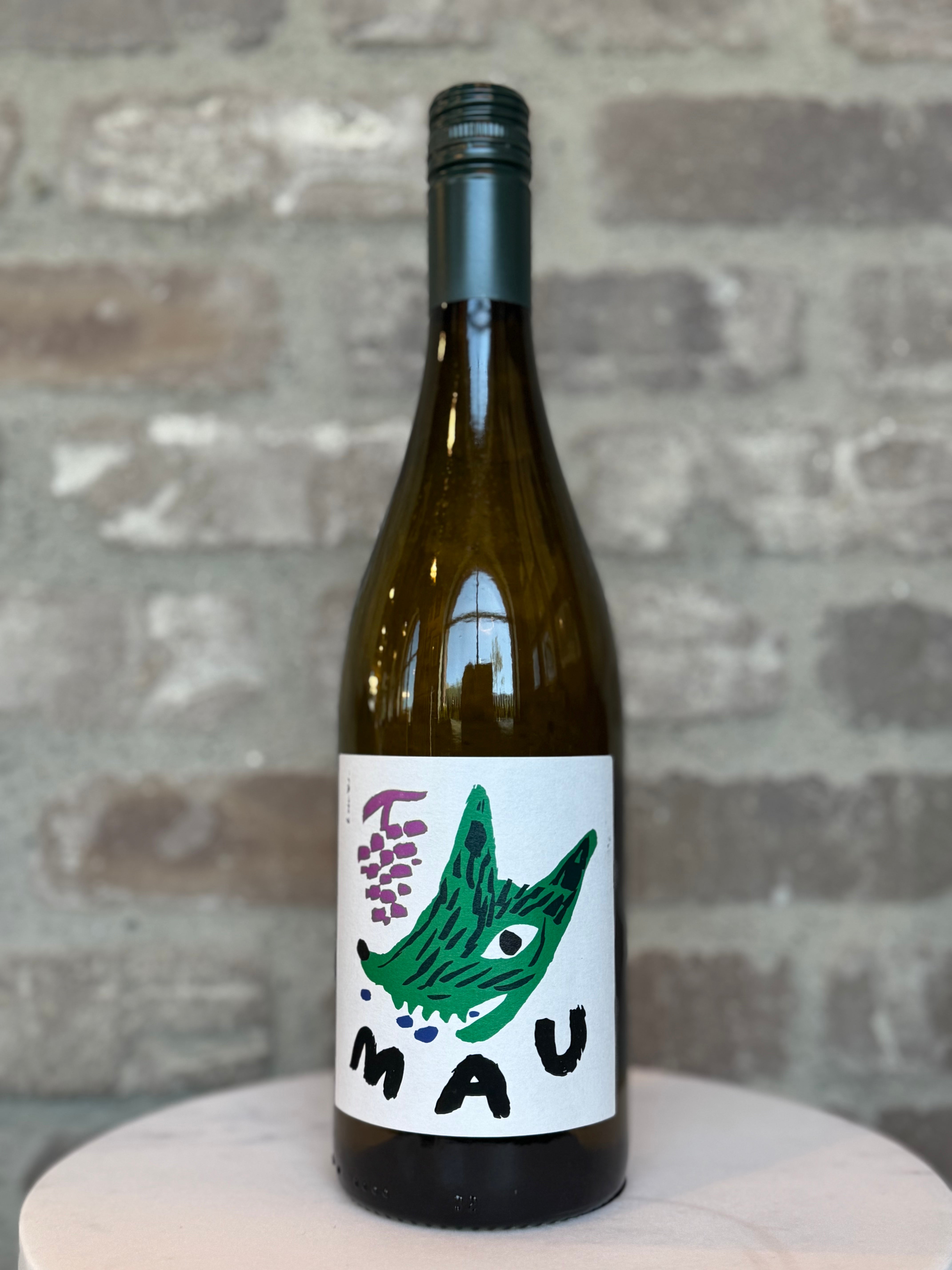 Wine bottle with a colorful label featuring a green fish and the word 'MAU' against a brick wall background.