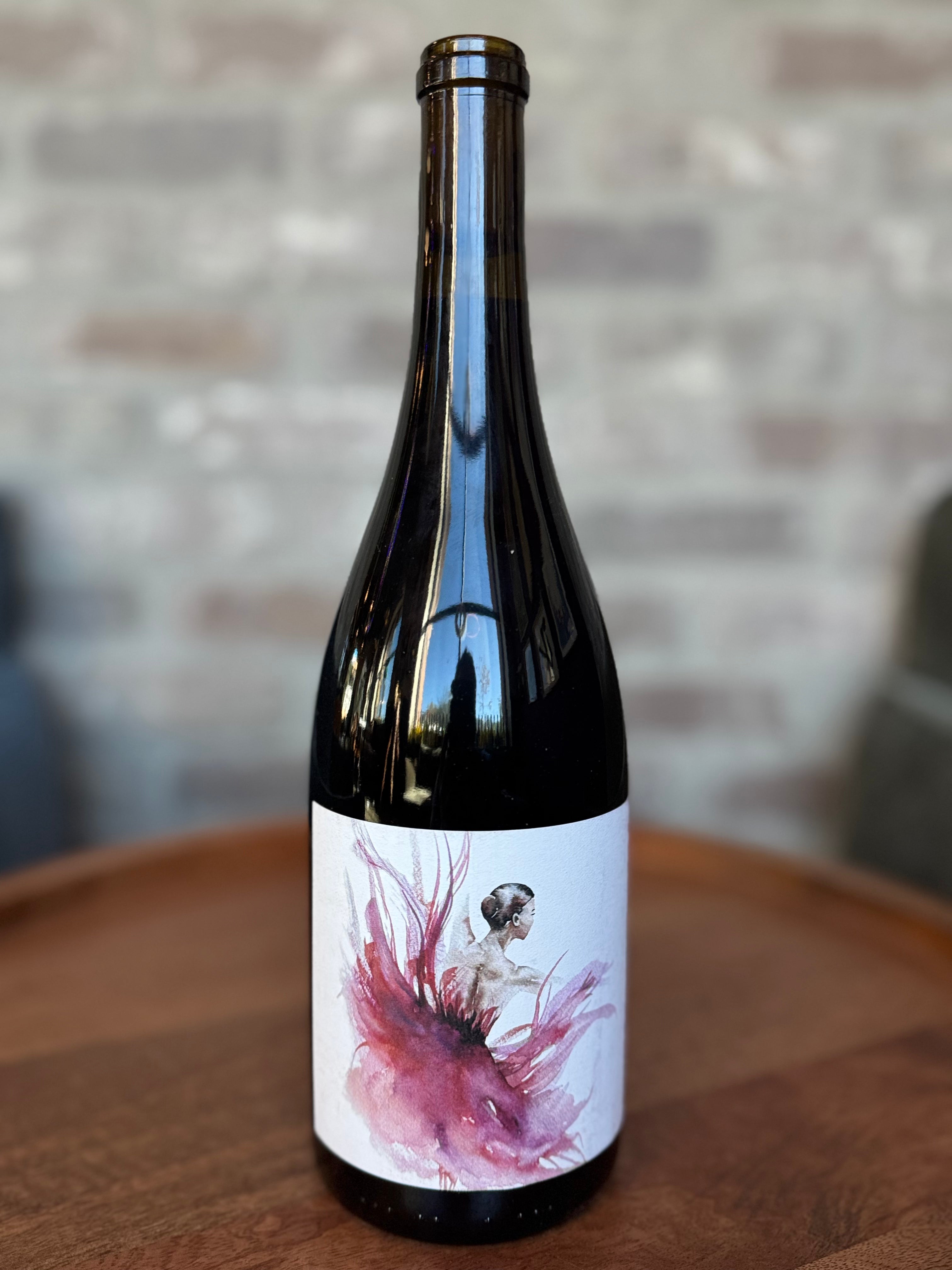 Wine bottle with artistic label on a wooden table