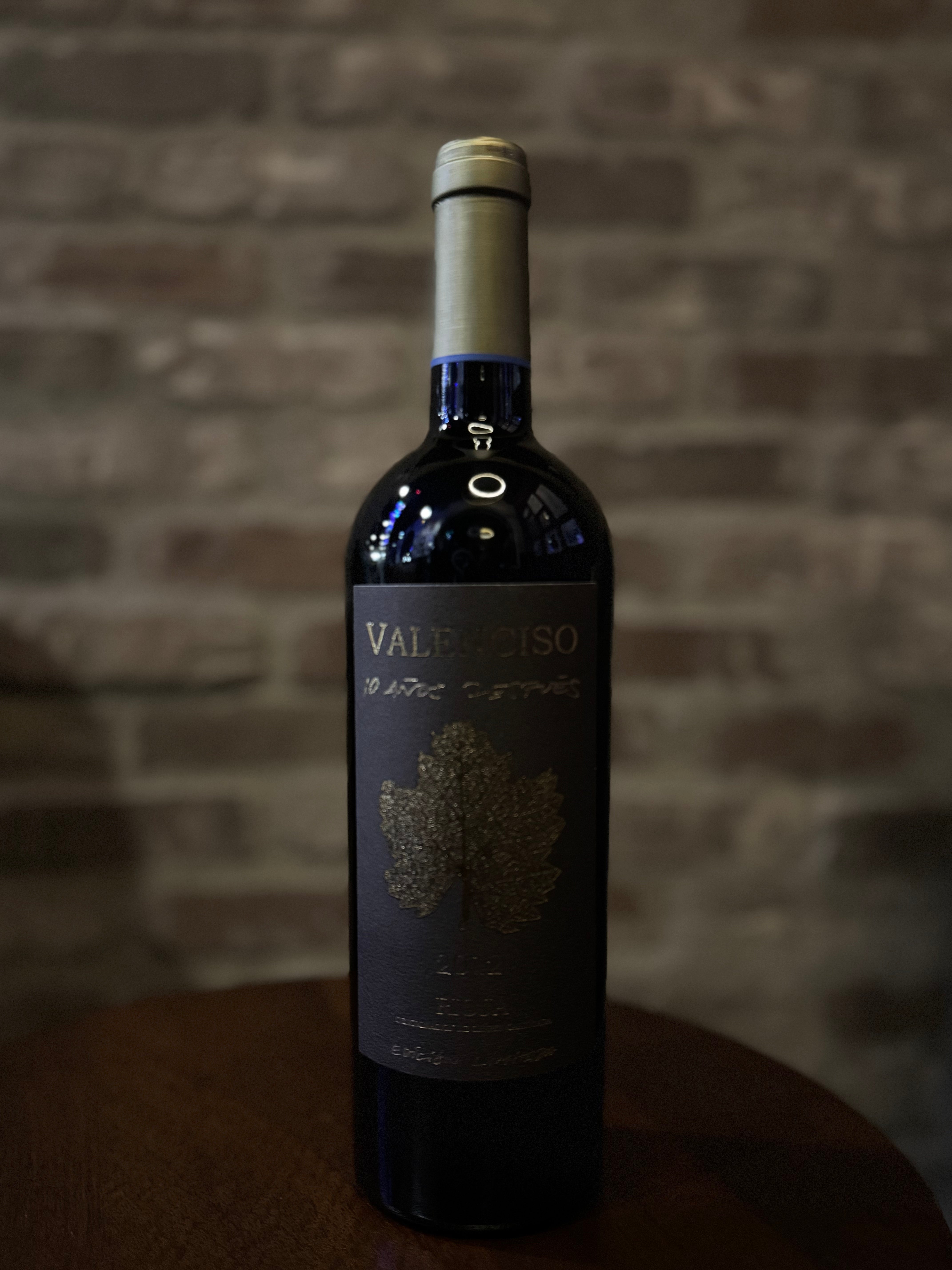 Wine bottle labeled 'Valleliso' against a brick wall background