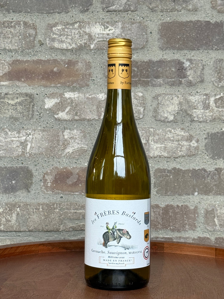 Wine bottle with a label on a wooden surface and stone wall background