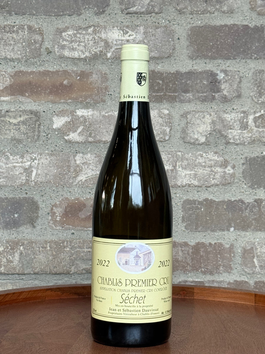 Wine bottle with a label on a wooden surface and stone wall background