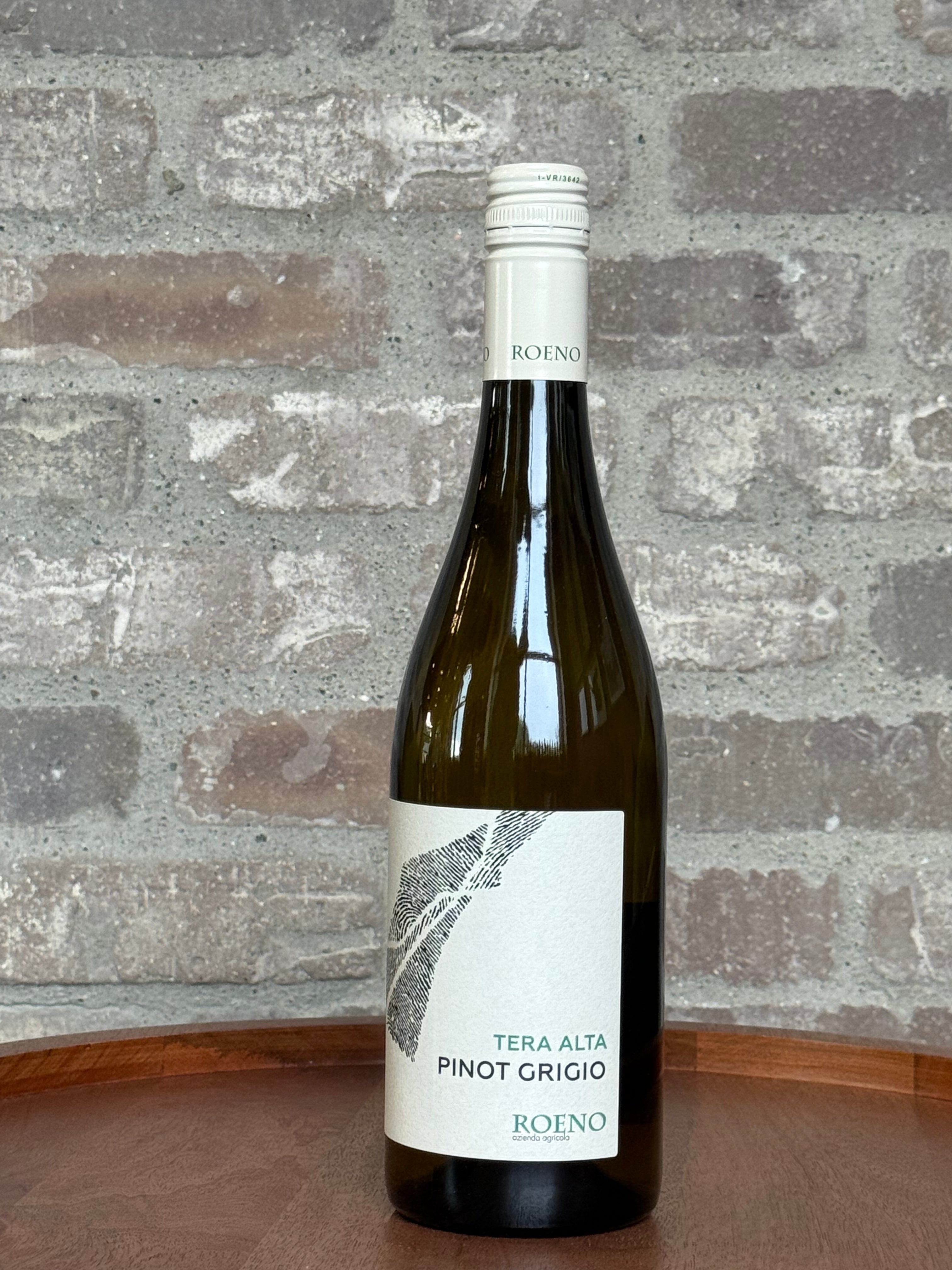 Wine bottle of Tera Alta Pinot Grigio Roено against a stone wall background