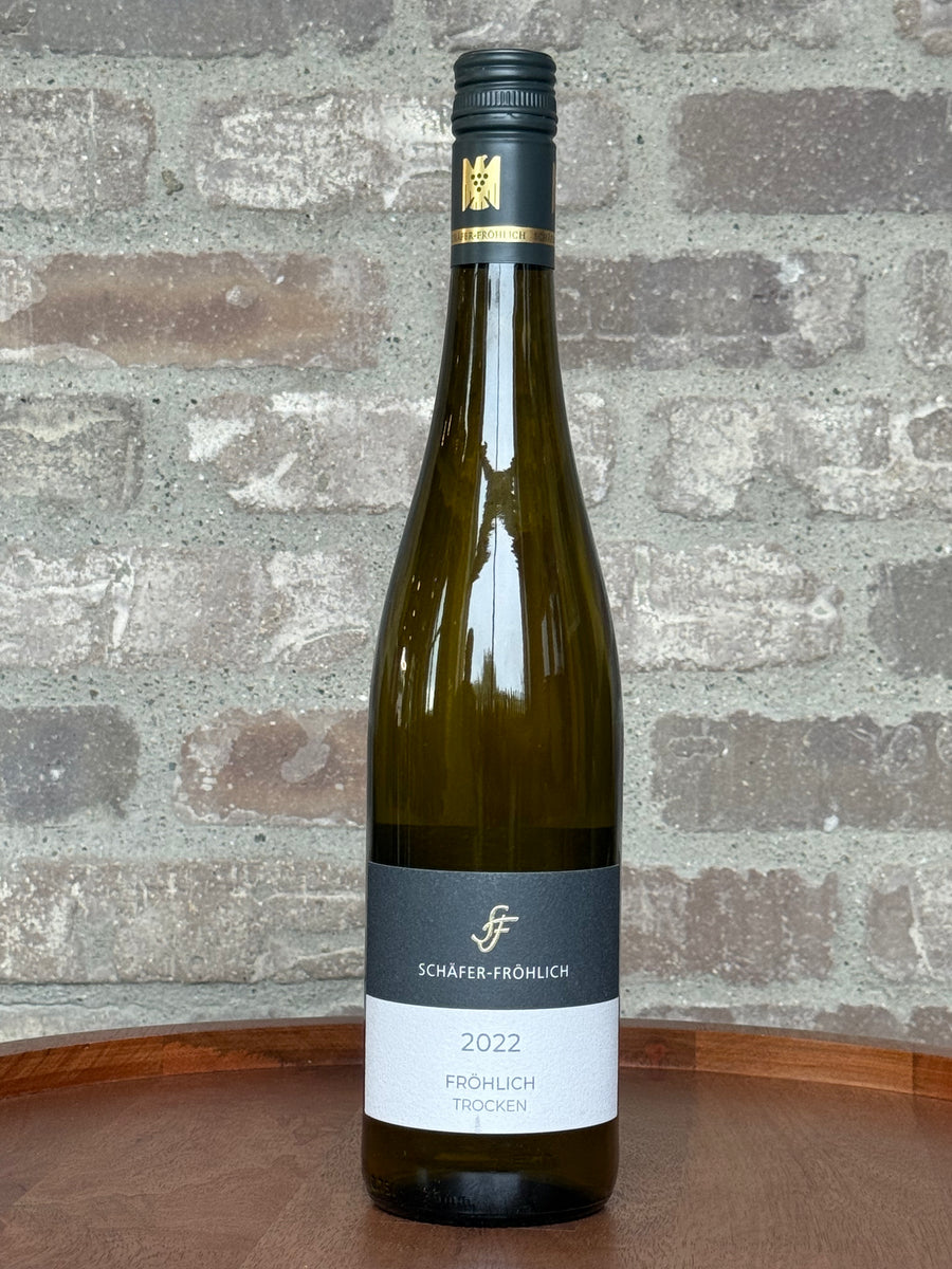 Wine bottle with label on a wooden surface and stone wall background