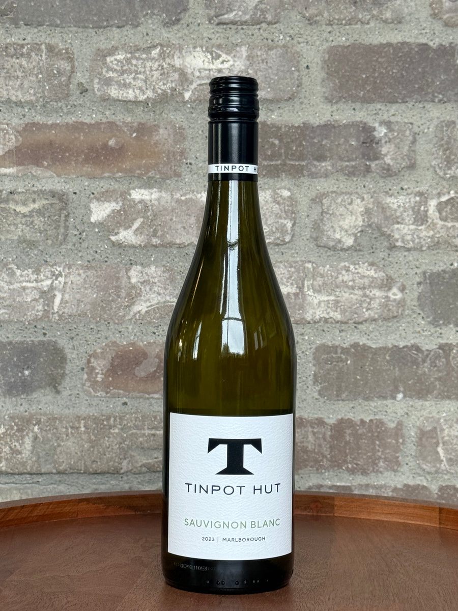 Bottle of Tinpot Hut Sauvignon Blanc wine against a stone wall background