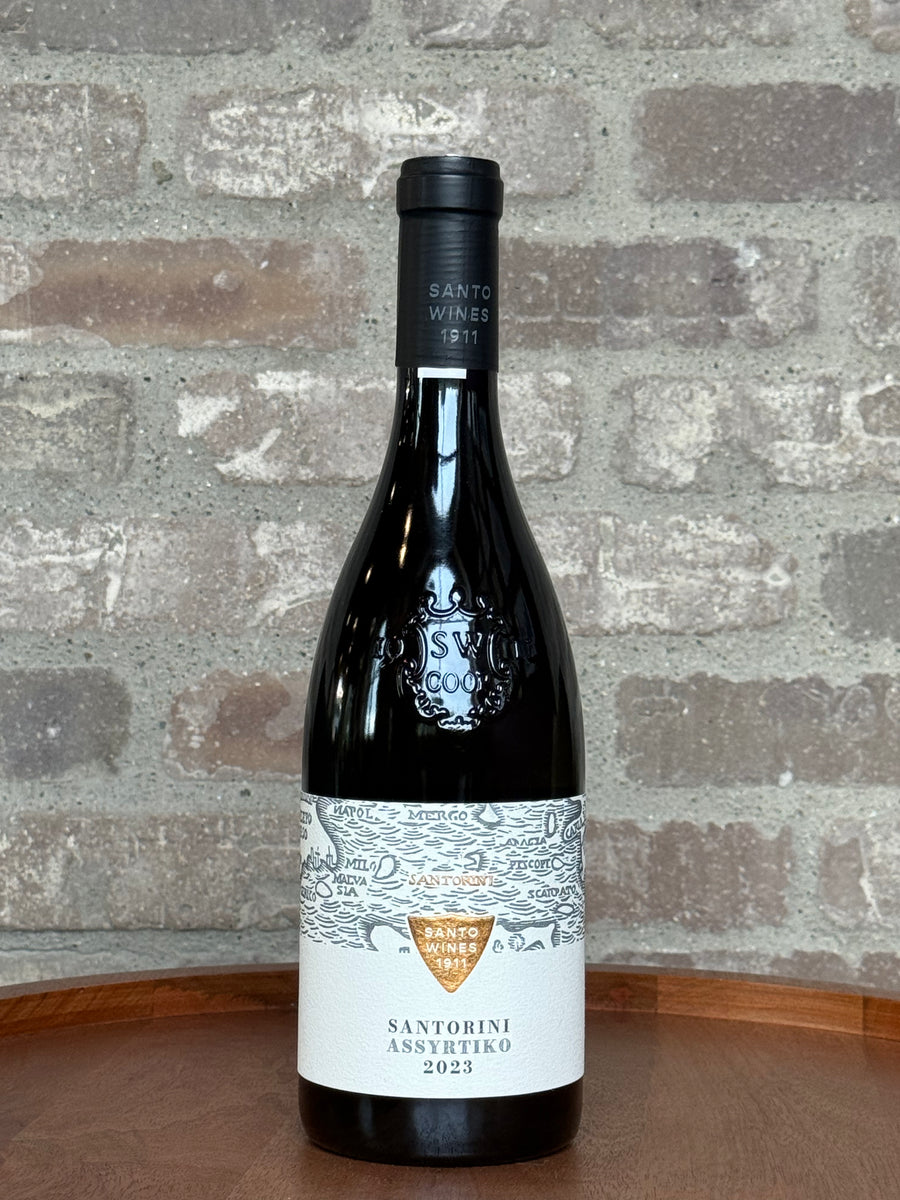 Wine bottle with label on a wooden surface and stone wall background