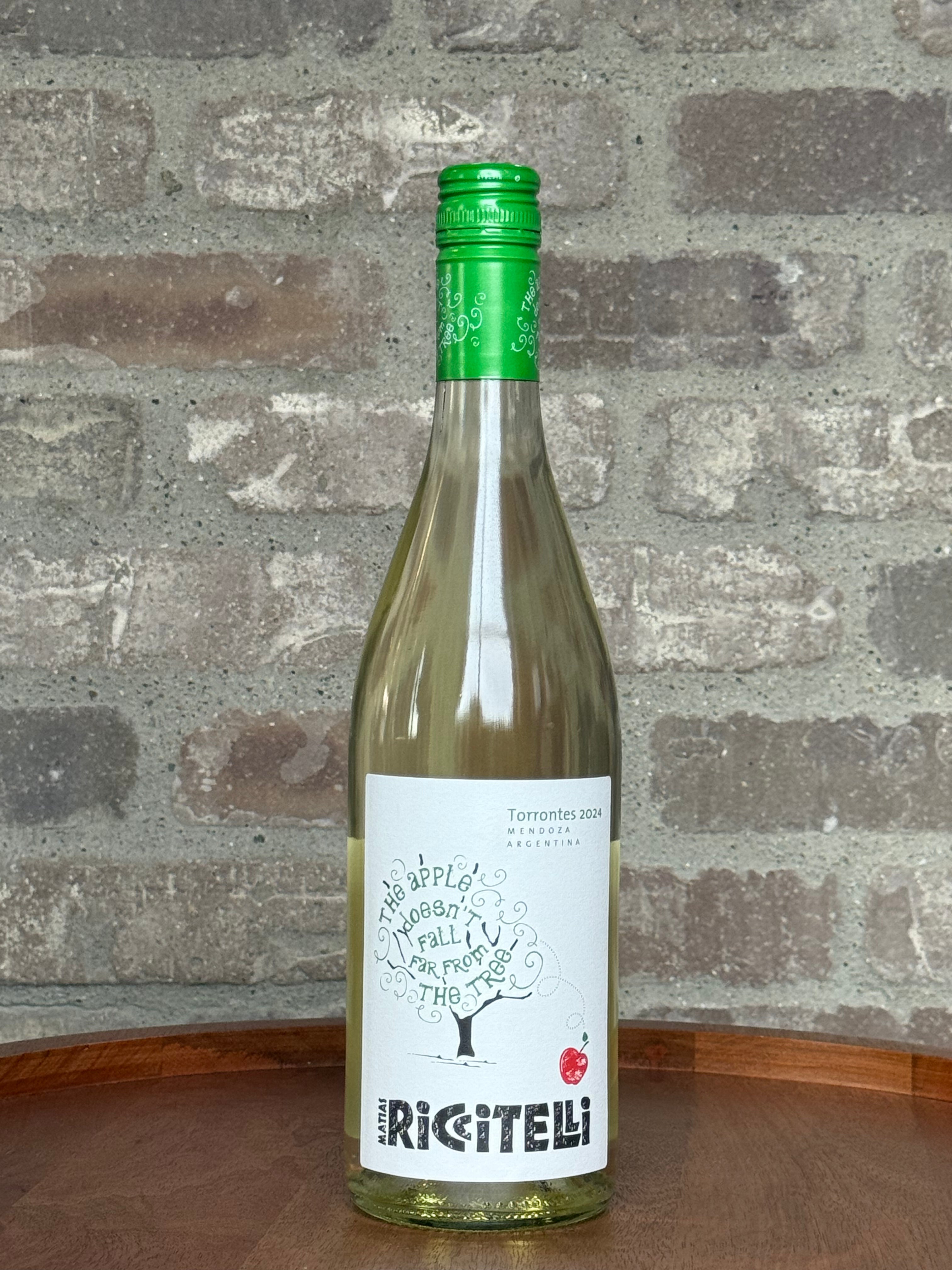 Bottle of Rigitelli wine with a green cap on a wooden surface against a brick wall.