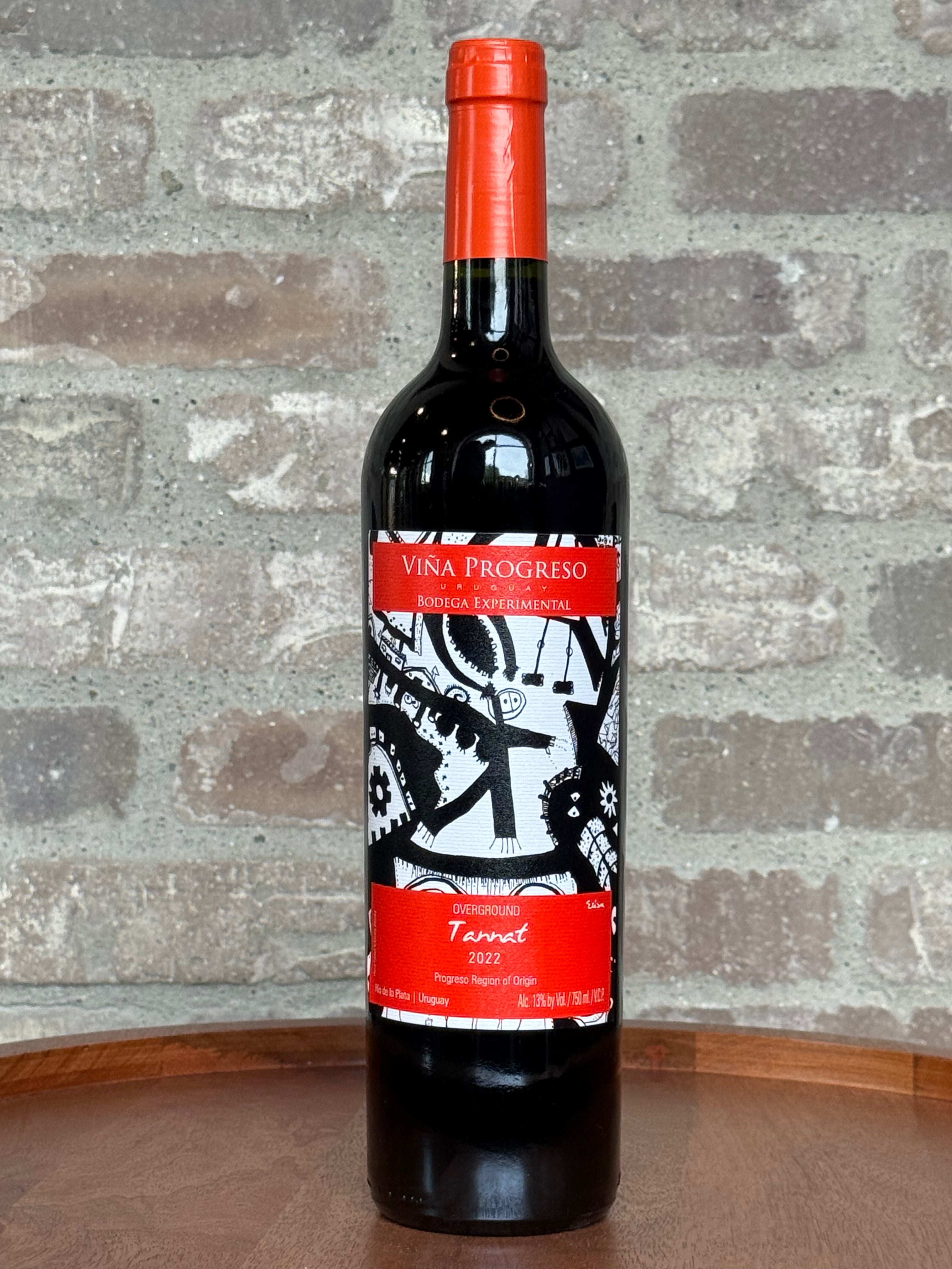 Red wine bottle with a decorative label on a stone surface