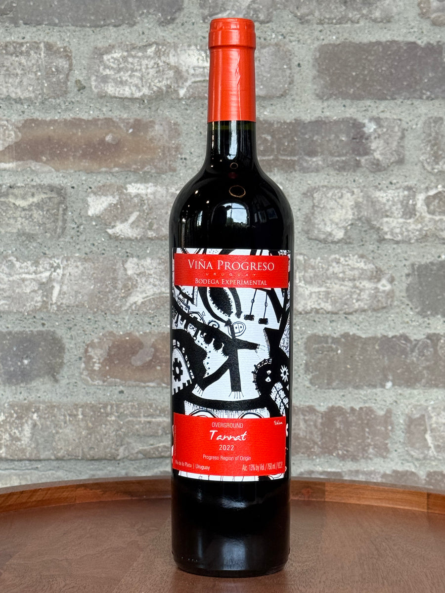 Red wine bottle with a decorative label on a stone surface