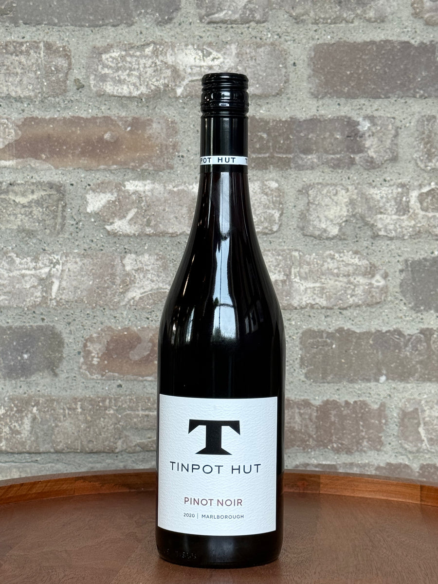 Bottle of Tinpot Hut Pinot Noir wine against a stone wall background