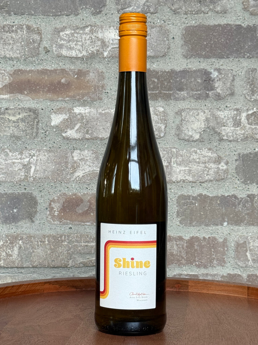 Bottle of Shine Riesling wine against a stone wall background