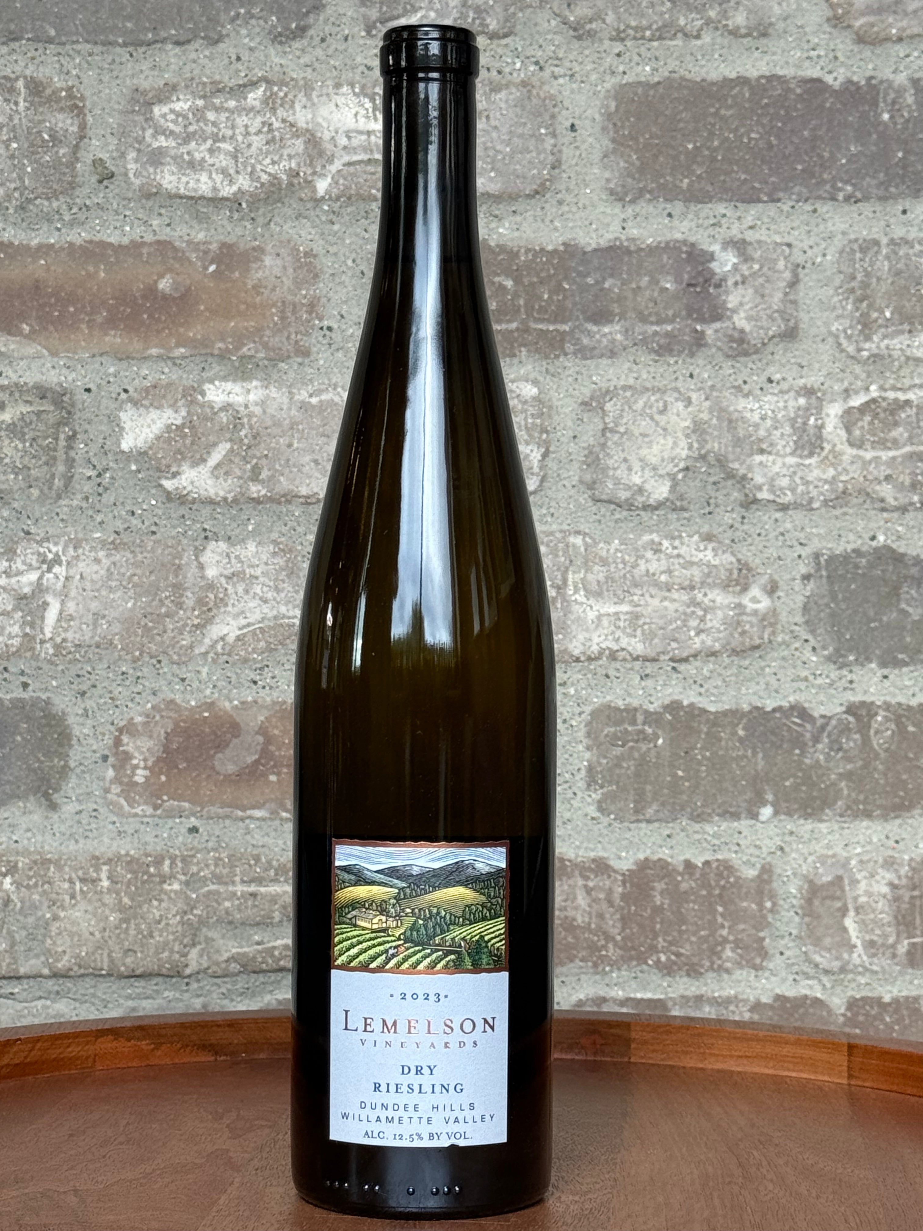 Wine bottle with label on a wooden surface and brick wall background